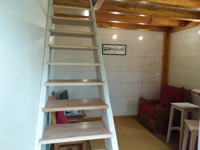 Escalier en bois clair menant à la mezzanine dans la chambre 'MAKILA', avec coin salon confortable, chez GOITIK IKUSITA.