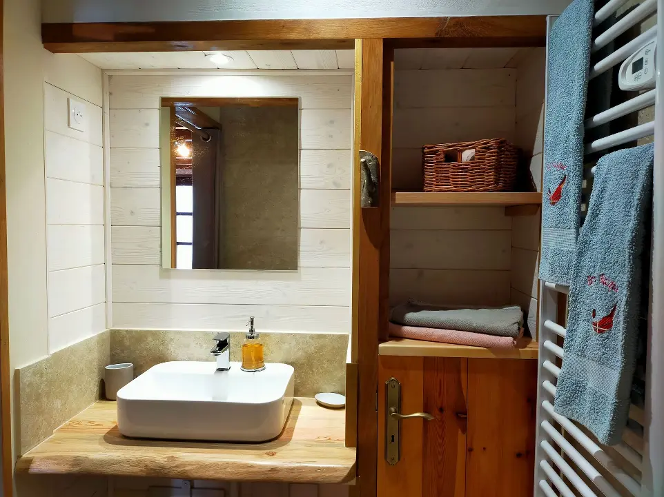 Salle de bain avec des éléments en bois, un lavabo dans le gîte Goitik Ikusita à Ainhoa.